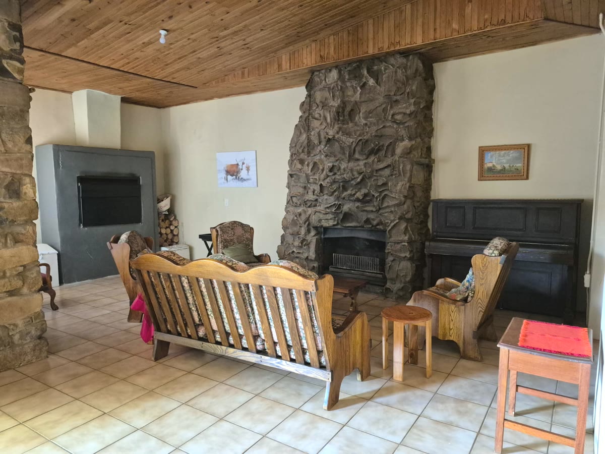 Lounge with a big stone fireplace and an upright piano